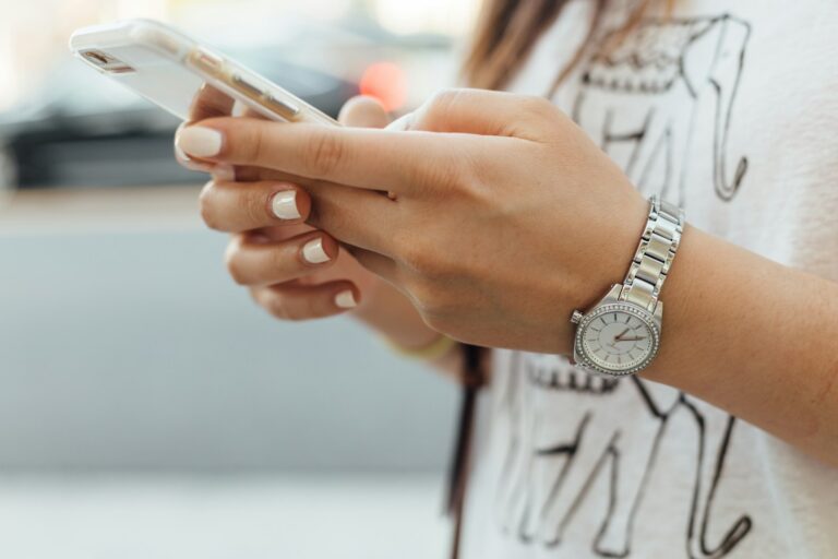 Person holding an affordable smartphone with the home screen visible