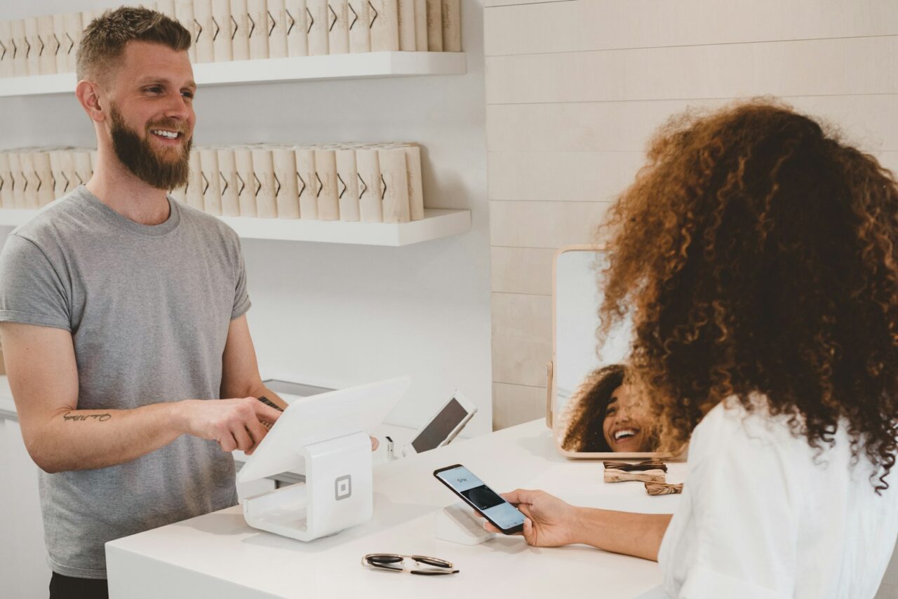Small shop owner using a tablet to manage orders behind the counter