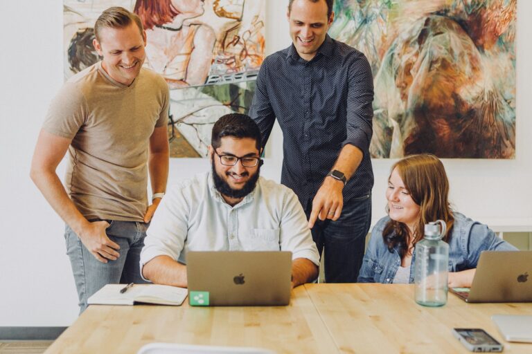Team sketching an app workflow on a whiteboard next to a laptop