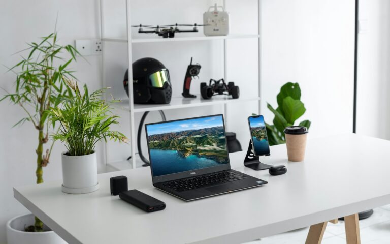 Laptop and smartphone on a desk while comparing tech purchases in 2026