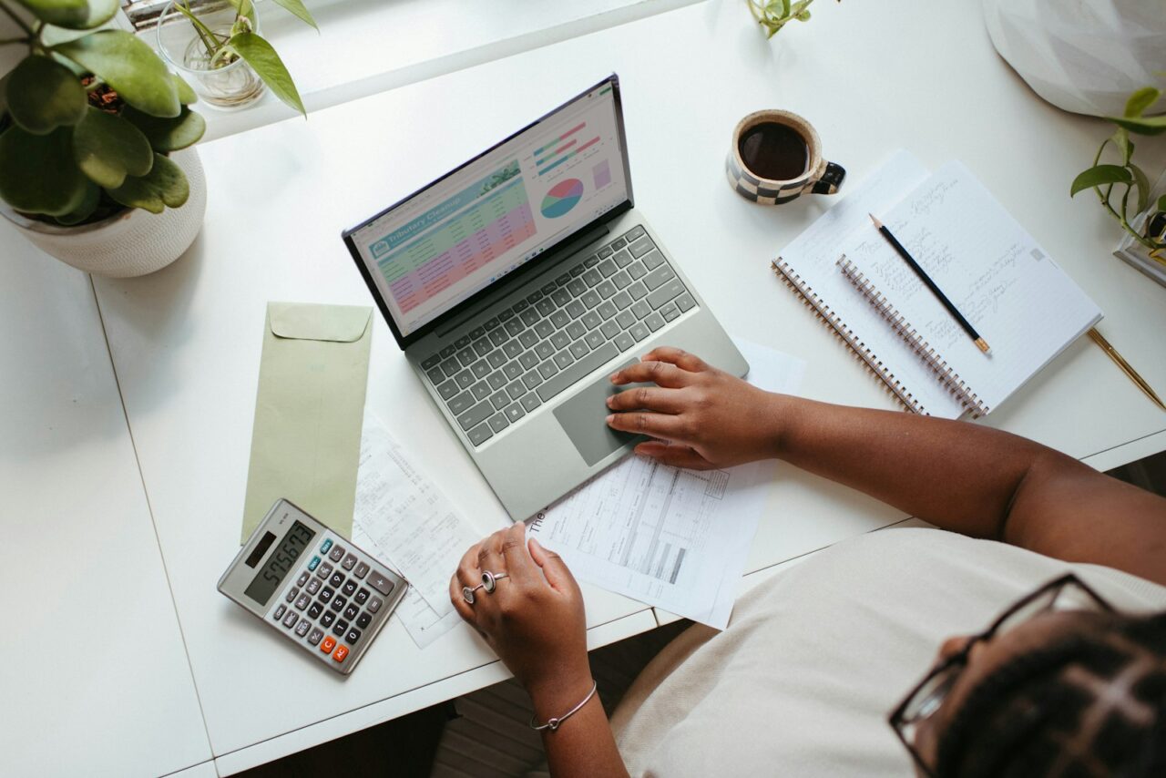 Freelancer reviewing a budget spreadsheet on a laptop at a home office desk