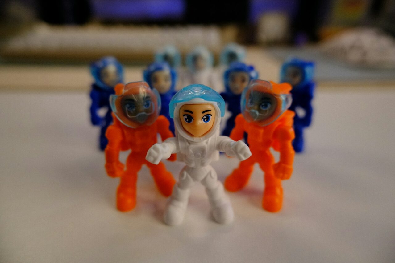 A collection of character action figures and plush toys displayed on a shelf